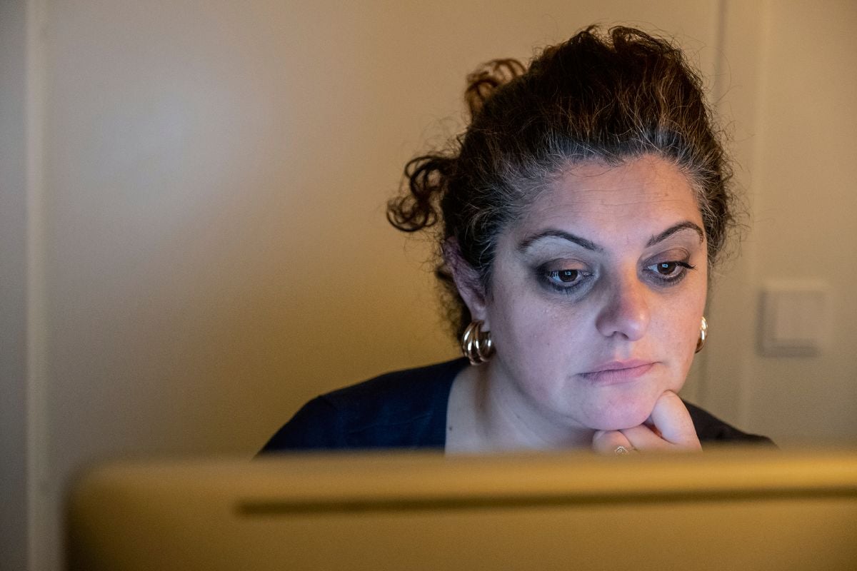 En kvinna betraktar tankfullt en datorskärm.